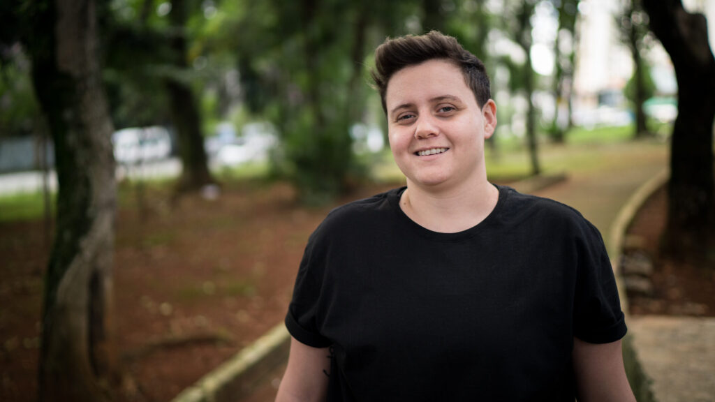 Person in a black T-shirt surrounded by trees